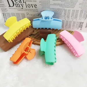 Detailed macro view of five colorful rectangular hair claw clips in various matte dopamine colors