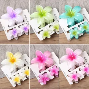 Detailed macro view of six colorful frangipani flower hair claw clip sets in a grid