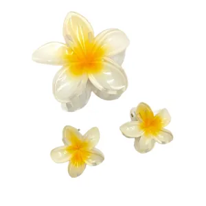 Close-up detail of 3-piece frangipani flower hair claw clip set for summer vacation
