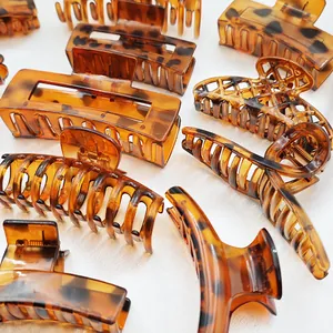 Close-up detail of various large tortoise shell patterned plastic hair claw clips for updos