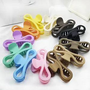 Large matte bow-shaped hair claw clips in multiple vibrant colors arranged in a circle.