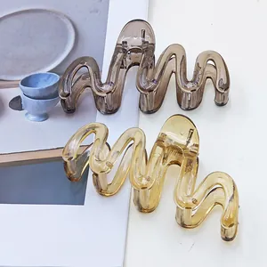 Close-up detail of wavy jelly hair claw clips showing translucent amber texture.