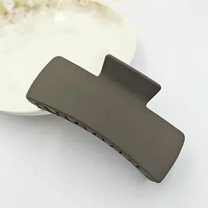 Detailed macro view of a large matte brown square hair claw clip for elegant updo styles.