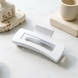 Detailed view of a minimalist large white square hair claw clip on aesthetic stone props