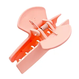 Detailed view of matte peach pink rectangle hair claw clip with sturdy metal spring