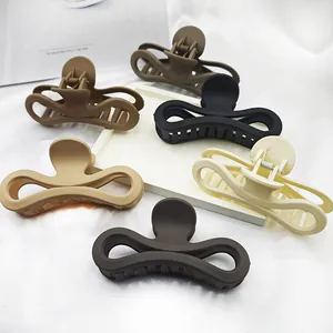 Detailed view of matte figure-eight hair claw clips in various neutral earth tones