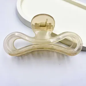 Detailed macro view of minimalist jelly champagne hair claw clip with golden spring.