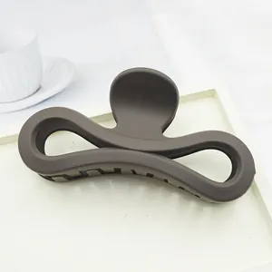 Close-up of a large matte dark brown hair claw clip with a figure-eight hollow design.