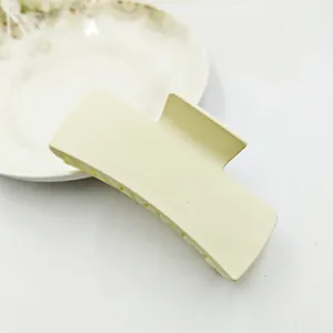 Detailed shot of a matte creamy yellow rectangular hair claw clip for stylish hair styling