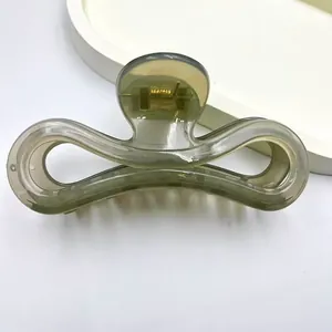 Detail shot of a minimalist jelly olive green hair claw clip with a glossy finish
