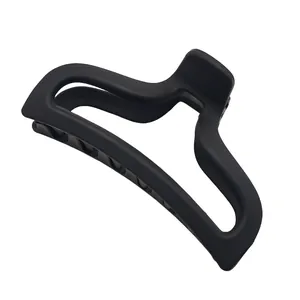 Detail view of a matte black minimalist hair claw clip with a sleek geometric design