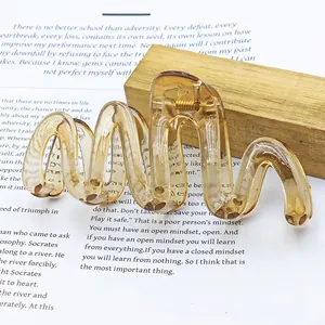 Detailed view of a large wavy jelly-colored amber brown hair claw clip for women