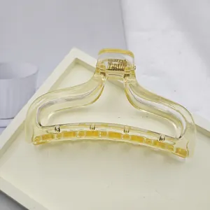 Macro view of a large translucent yellow hair claw clip with smooth arc design