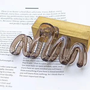 Macro view of large jelly brown wavy hair claw clip on literary book background