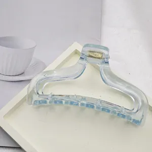 Close-up view of a minimalist light blue transparent acrylic hair claw clip on tray