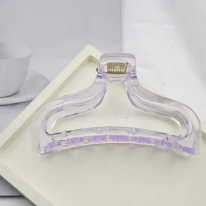Close-up view of a minimalist purple translucent hair claw clip on a white display tray