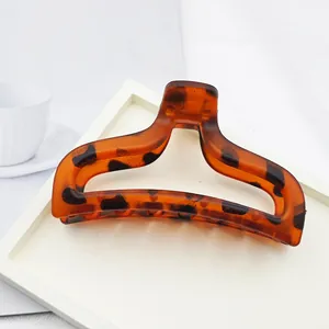 Detailed view of a tortoise shell leopard print hair claw clip on a white tray