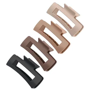 Detailed view of four large matte square hair claw clips in diverse neutral colors