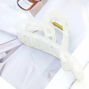Nahaufnahme der eleganten herzförmigen Haarklammer in Off-White auf einer Zeitschrift