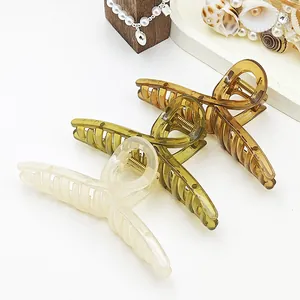 Three large jelly-textured hair claw clips in cream, olive, and amber colors.