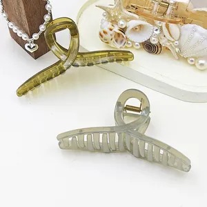 Close-up of translucent jelly hair claw clips in olive green and light grey.