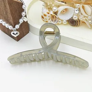 Close-up of a large translucent grey jelly hair claw clip with a ribbon twist design