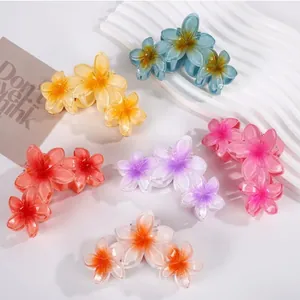 Detailed view of colorful frangipani flower hair claw clips for summer vacation