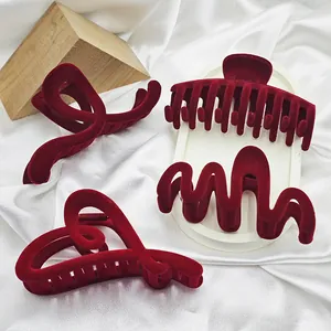 Detailed view of four elegant red velvet hair claw clips in varied geometric shapes