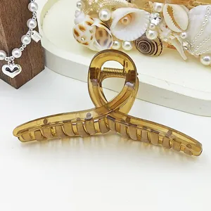 Close-up of a large amber jelly ribbon hair claw clip with a glossy finish