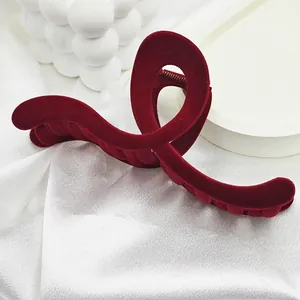 Detailed view of the luxurious burgundy velvet texture on a large curved hair claw clip