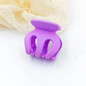 Detailed macro view of a small purple matte hair claw clip for securing high ponytails.