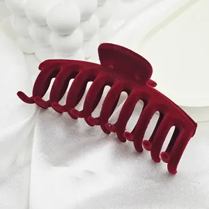 Close-up of large burgundy red velvet flocked hair claw clip with soft texture.