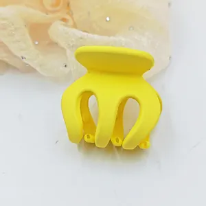 Detailed macro view of a vibrant yellow matte hair claw clip for hair styling