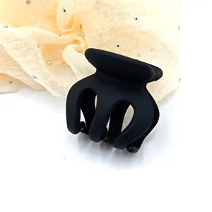 Close-up view of a small matte black hair claw clip featuring a durable multi-prong design
