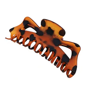 Detailed view of a large matte leopard print hair claw clip for women on white background