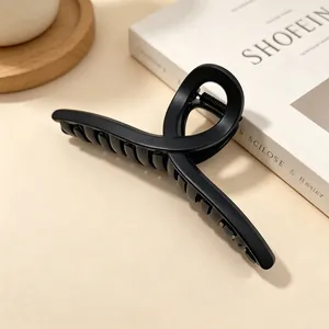 Detail view of a large 13cm matte black hair claw clip on a minimalist background