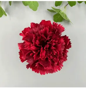 Top view of a deep red artificial carnation flower head with detailed fabric petals.