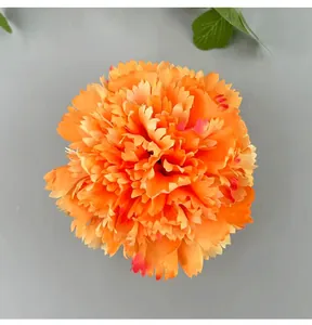 Close-up detail of a vibrant orange artificial carnation flower head for DIY wedding decor