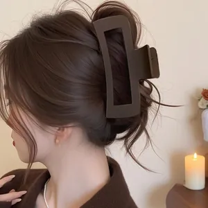 Side view of a large matte brown square hair claw clip styled on long wavy hair.