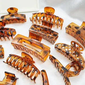 Detailed view of assorted tortoiseshell leopard print hair claw clips on white fabric