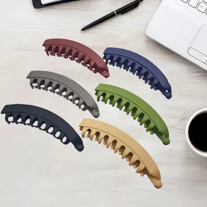 Set of six premium matte banana hair clips in multiple colors displayed on a wooden desk