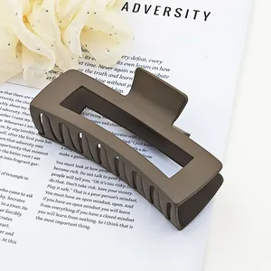 Detail view of a large matte mocha brown square hair claw clip on a stylish background.