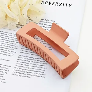 Detailed macro view of an oversized matte peach square hair claw clip for thick hair