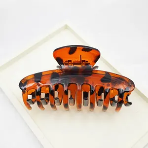 Macro view of large leopard print hair claw clip with glossy tortoiseshell finish