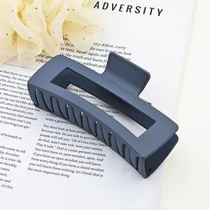 Close-up of matte dark blue square hair claw clip on magazine background