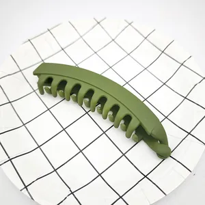 Detail shot of a matte olive green banana hair clip for thick hair on a grid plate