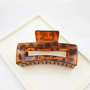 Detail showing the glossy texture of a large leopard print hair claw clip accessory.
