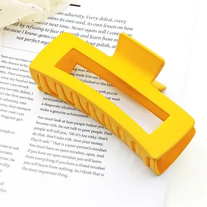 Detailed view of a large yellow matte square hair claw clip for thick hair styling.