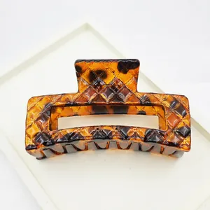 Detailed close-up of large leopard print hair claw clip with geometric diamond texture