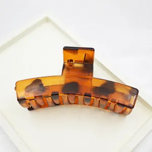 Detailed view of a large leopard print plastic hair claw clip for elegant hair styling